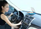 Heads-up display projector mounted on a car dashboard while a driver holds the steering wheel