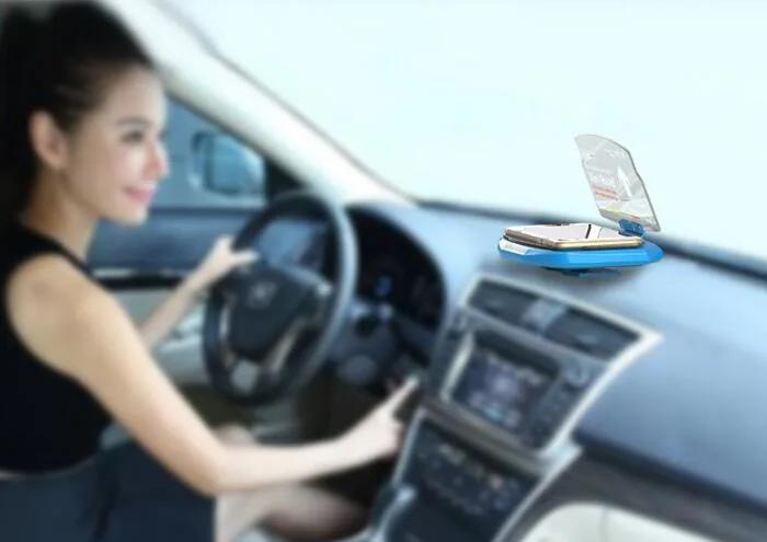 Heads-up display projector mounted on a car dashboard while a driver holds the steering wheel