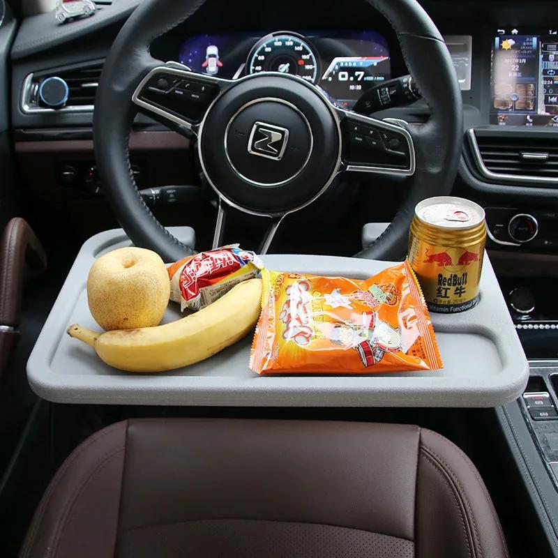 Steering wheel tray hooked over the wheel holding food