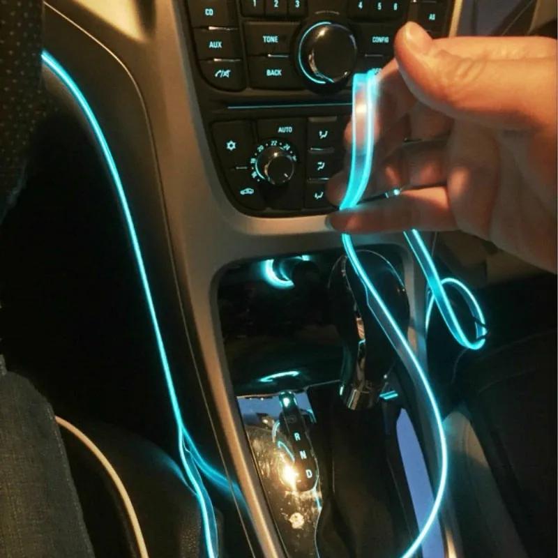 A hand tucking the ice blue EL wire into the gap in the dashboard trim