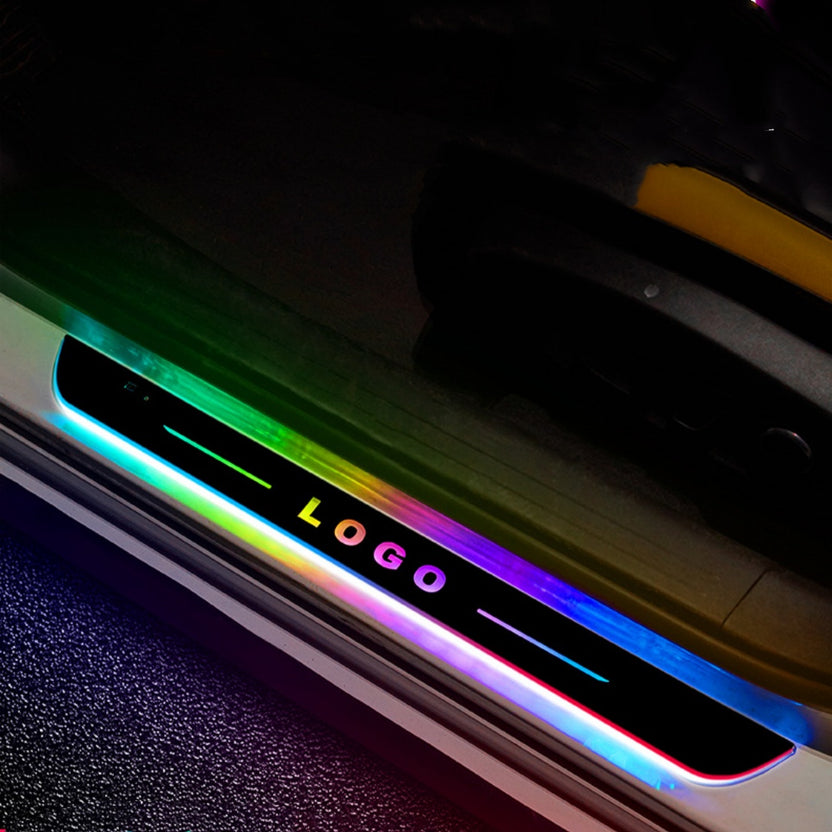 Illuminated LED door sill plate glowing rainbow colours on a car door threshold at night