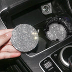 Hand placing a silver crystal coaster into a car cup holder