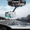 Phone mounted in the rear-view mirror holder showing navigation while driving on a motorway