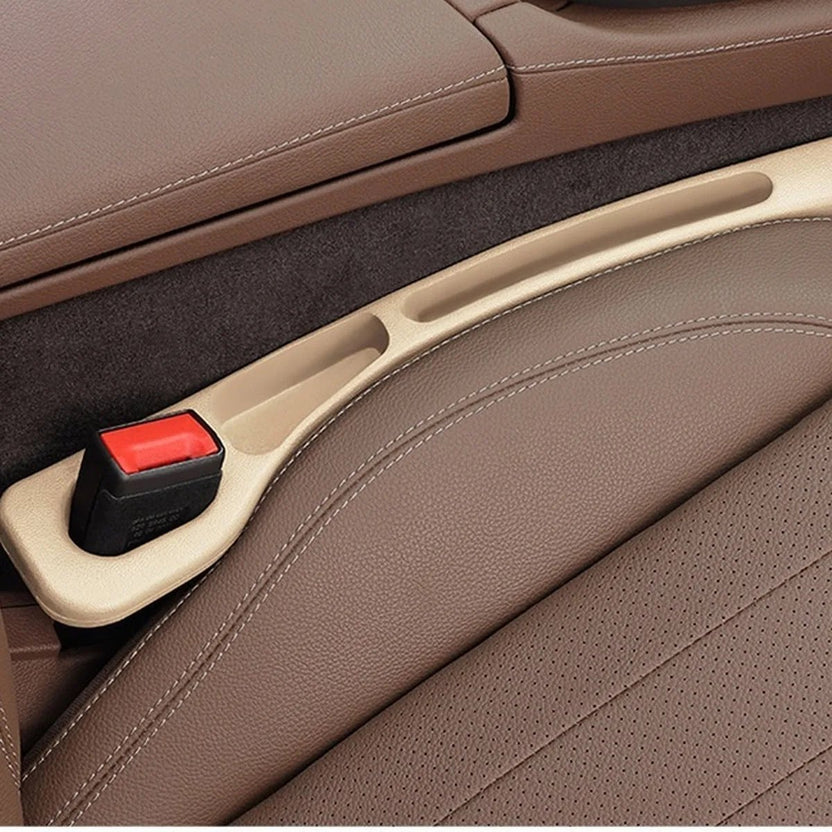 Beige — car seat gap filler strip fitted in the gap beside the seat, seat-belt buckle sitting in the moulded cutout