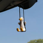 Car rearview mirror duck charm hanging from the rearview mirror against the windscreen